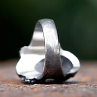 Angled shot showcasing the robust stainless steel band and the overall punk aesthetic of the ring.