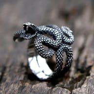 Close-up of the snake head on the 316L stainless steel ring, showing open mouth with fangs and textured scales.