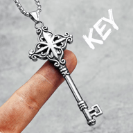 Ornate 316L stainless steel key pendant necklace held on a finger, showcasing detailed design