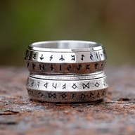 Viking rune spinner ring displayed on a weathered dark surface