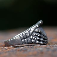 Close-up detail of the left skeletal hand design on the 316L stainless steel heart ring, showcasing the intricate bone articulation and texture.