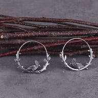 Gothic stainless steel raven hoop earring worn on an ear to show proportions and drape