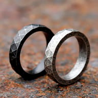 Focus on the dark, engraved Futhark runes adorning the outer edge of the stainless steel band.