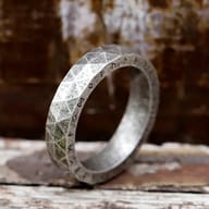Detailed close-up showing the intricate polygonal facets and brushed finish of the Viking ring.