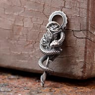 Close-up of textured snake scales and rose petals on gothic stainless steel pendant
