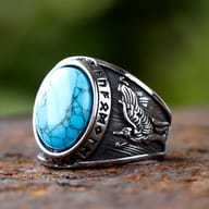 Detailed view of the Viking wolf ring highlighting the intricate carving of the wolf against a blurred green background.
