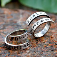 Angled view of the stainless steel rune ring, capturing the split band design and textured surface.