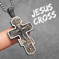 Two-tone 316L stainless steel Orthodox Crucifix pendant, held in hand against grey background.