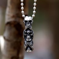 Three wise skulls gothic stainless steel pendant hanging on a ball chain