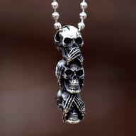 Front detail of the stacked three wise skulls pendant showing oxidized finish