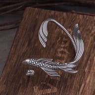 Detailed view of the sculpted tail fin on a 316L stainless steel ear cuff
