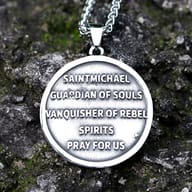 Close-up of the top left of the St. Michael pendant and chain on a textured background.