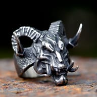 Detailed view of the curved, ridged ram horn on the gothic devil skull ring.