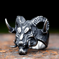 Darkened stainless steel gothic devil skull ring with large curved horns, prominent lower tusks, and detailed skeletal facial features.