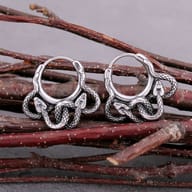 Close-up of the upper part of one 316L stainless steel snake hoop earring, showing its hinge mechanism and coiled snake design.