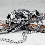 Close-up of the top part of the saber-toothed tiger skull pendant, showing the bail and chain connection.
