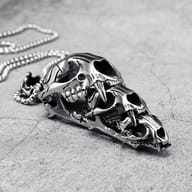Side view close-up of the saber-toothed tiger skull pendant, emphasizing the prominent fangs and jaw.