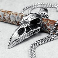Close-up of the stainless steel crow skull pendant's bail and chain attachment, showcasing detail.