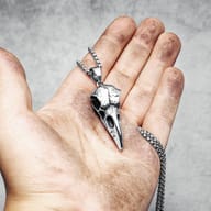 Frontal close-up of the 316L stainless steel crow skull pendant's beak and eye area on a clean background.