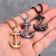 Detailed view of the top part of the stainless steel anchor pendant and chain, held by fingers.