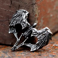 Lower section of the winged skeleton pendant, highlighting the leg bones and wing texture.