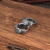 Side profile showcasing the detailed carved runes on the silver-tone huggie hoop