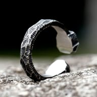 Side profile showing the rugged chiseled texture of the steel band