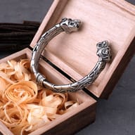 Close-up of sculpted wolf head terminals on stainless steel Norse cuff bracelet
