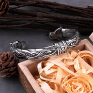 Angled perspective of stainless steel Viking torc bracelet with wolf head ends