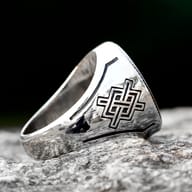 Side profile highlighting carved Norse geometric symbols on the tapered ring band