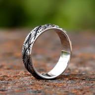 Angled shot highlighting the polished interior and detailed exterior of the eye pattern ring
