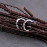 Angled shot highlighting the polished silver finish of the octopus tentacle earrings