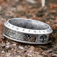 Angled shot focusing on the Tree of Life design and surrounding Futhark runes on the ring's surface.
