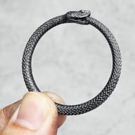 Angled shot highlighting the scale texture on the Ouroboros stainless steel pendant