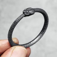 Side view of the Ouroboros pendant texture held by a finger