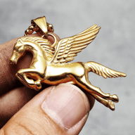 Pegasus pendant necklace displayed flat against a dark surface, showcasing its full length.