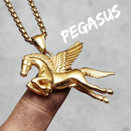 Golden Pegasus pendant necklace on chain, held by a finger against a grey background.