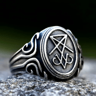 Oxidized stainless steel signet ring with an engraved Lucifer sigil on its oval face and detailed carved scrollwork on the band.
