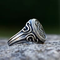 Close-up on the intricate details of the Lucifer emblem on the steel ring.