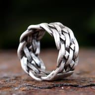 Detail view of the deep channels and raised braids on the steel ring's design.