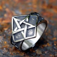Close-up of the pentagram ring's band texture and a small star detail on the side.