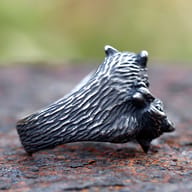 Profile view of the fox ring highlighting its intricate texture and form, with a soft blur in the background.