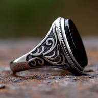 Top-down view of the black stone and silver bezel setting of the men's ring