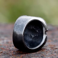 Top angle perspective of heavy gothic skull ring resting on rustic metal surface