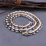Two-tone gold and silver Viking dragon scale chain necklace coiled on stone
