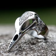 Side profile showing the intricate Celtic knotwork on the band of the raven ring