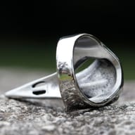 Stainless steel raven skull ring worn on a finger showcasing its statement fit