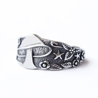 Close-up of the finely detailed leaves and flowers adorning the side of the vintage mushroom stainless steel ring.