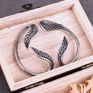 Front view of the curved stainless steel wing wrap earring showing carved feathers