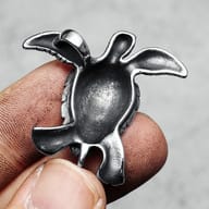 Detailed view of the 316L stainless steel turtle pendant's textured flippers and body.